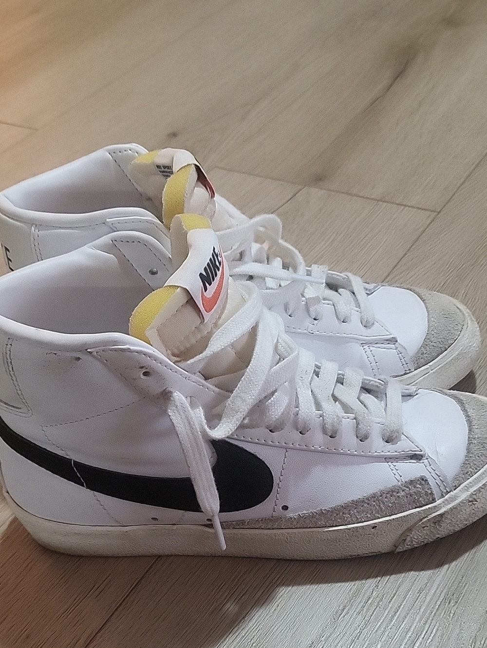 Nike White High-Top Sneakers with Black Swoosh and Yellow Tongue Tab